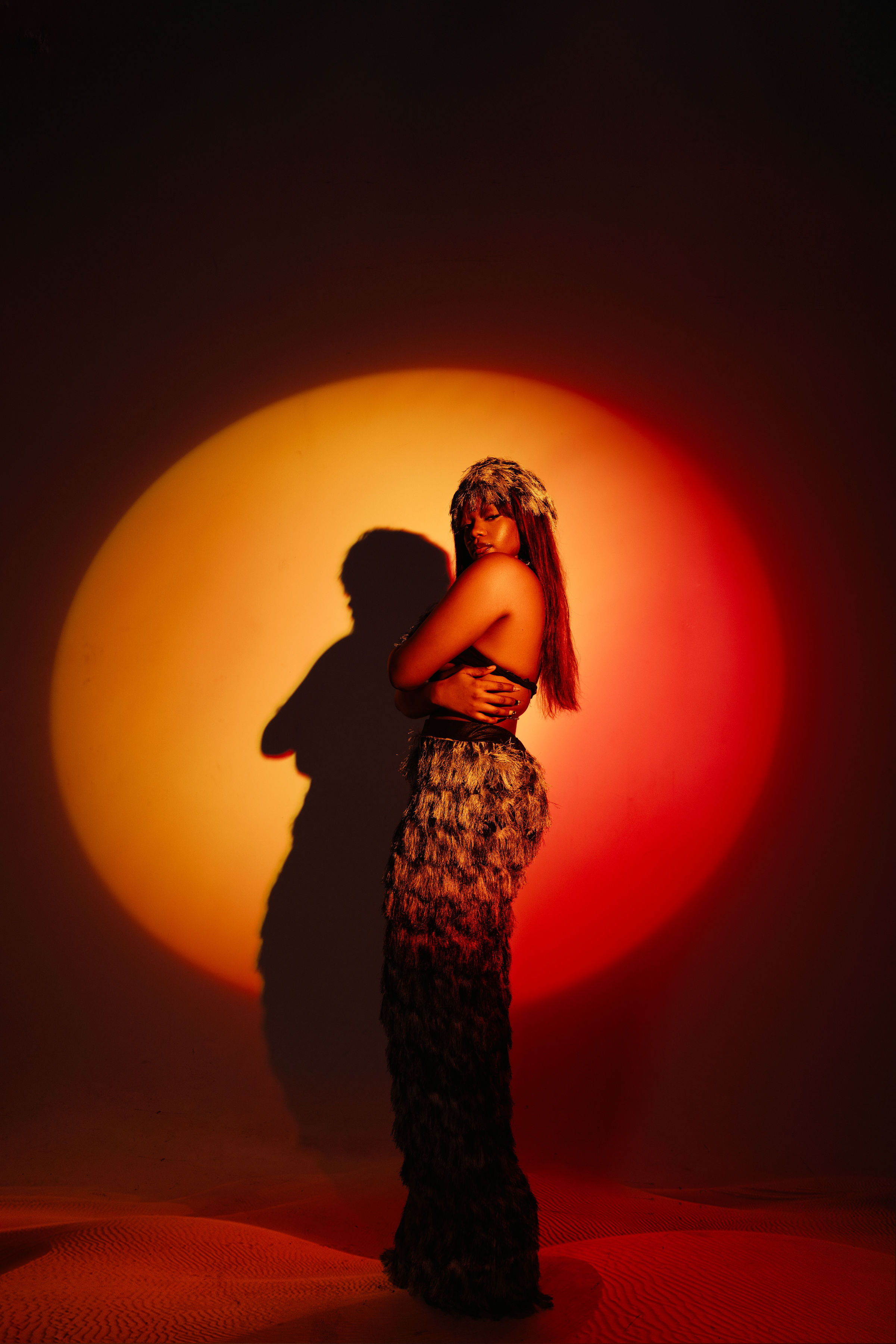 Artist portrait — sand dunes, orange and red circular light